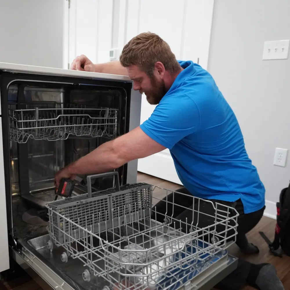 Dishwasher set into place under the counter with the racks pulled out during an installation visit