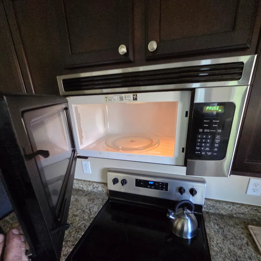 Over-the-range microwave mounted above a cooktop during an installation visit