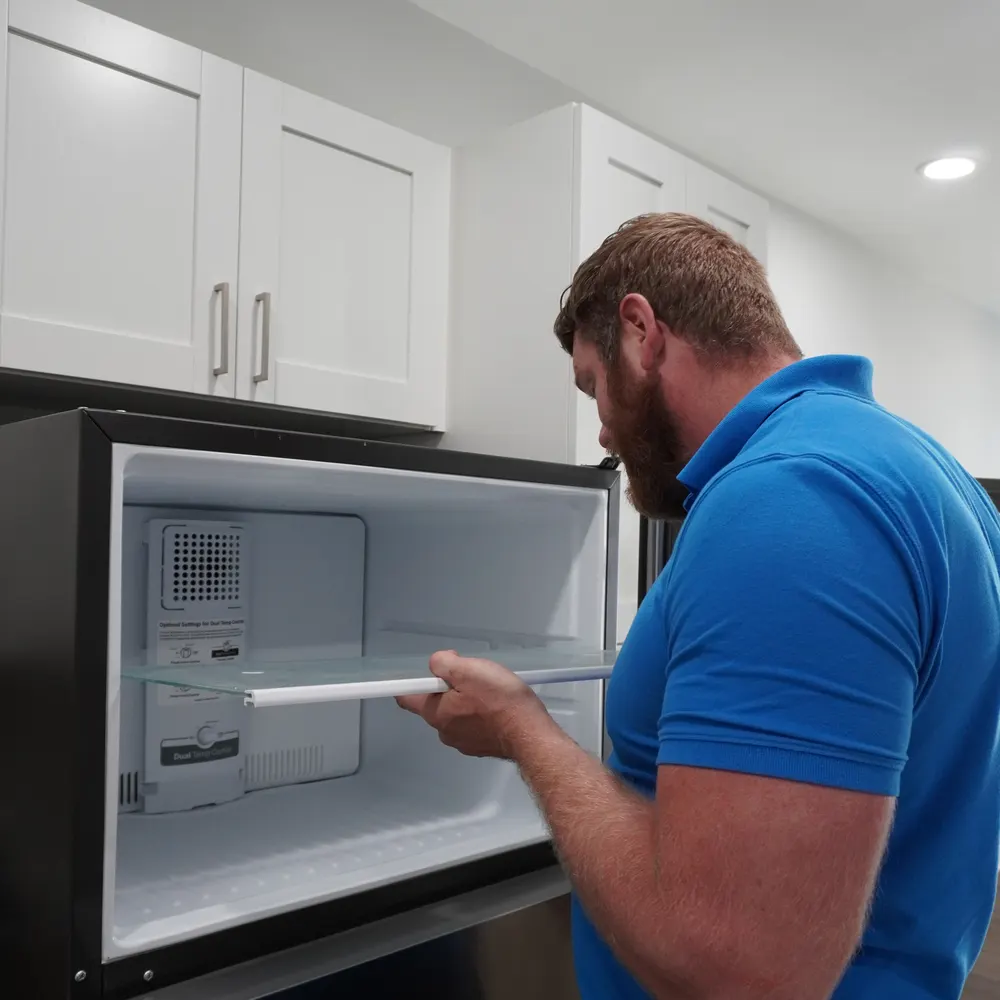 Nate inspecting a refrigerator's ice maker area during an Indianapolis-area service call